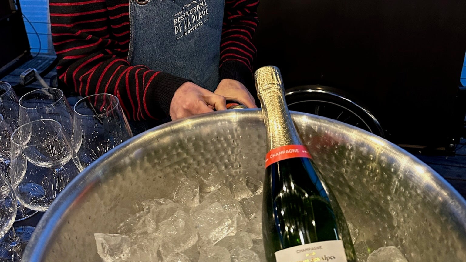 Bouteille de champagne Dragon des Alpes refroidie dans un seau à glace au restaurant, illustrant le bon entretien et la conservation à l’abri de la lumière